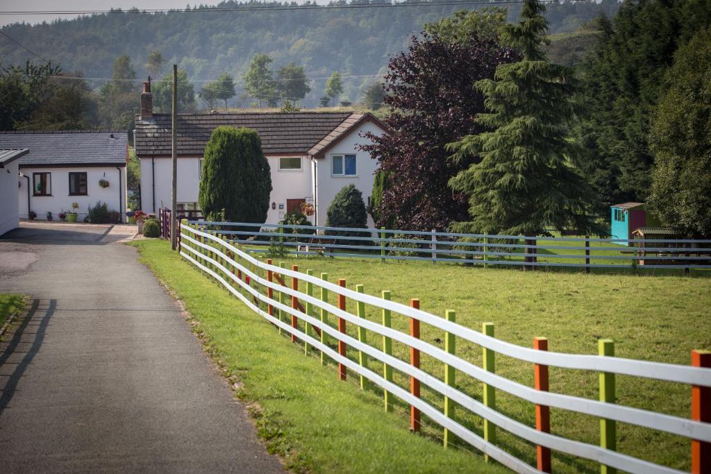 莫尔德Glan Llyn Farm House的房屋附近的白色围栏