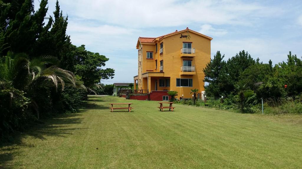 济州市军府度假屋的前面有两长椅的黄色建筑