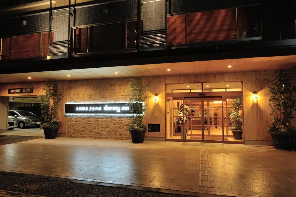 新泻滕恩温泉之汤新泻多米酒店的一间晚上有商店入口的建筑物