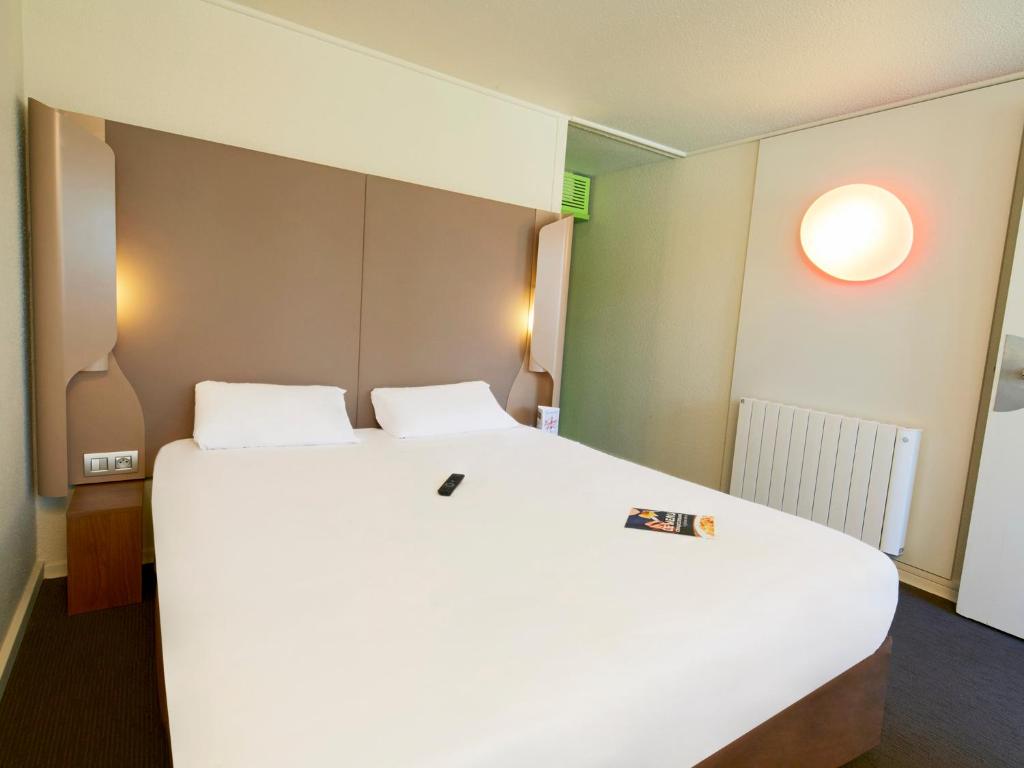 马尔桑奈拉科特第戎南马萨尼钟楼酒店的卧室配有一张白色大床