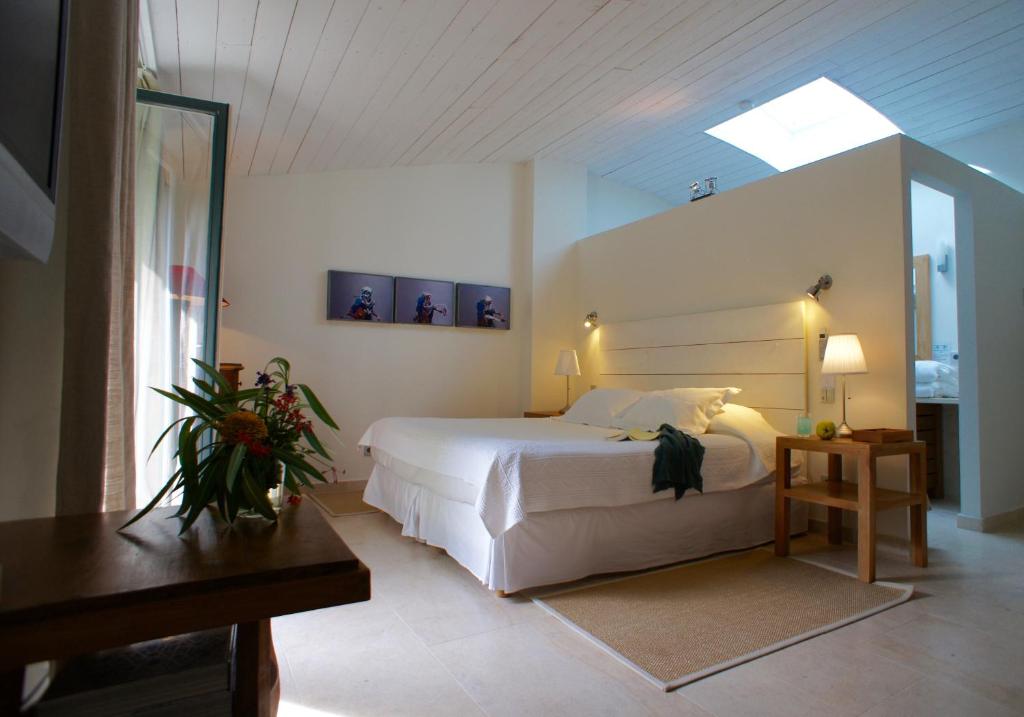圣特罗佩Campagne les Jumeaux的卧室配有一张白色的大床和天窗。