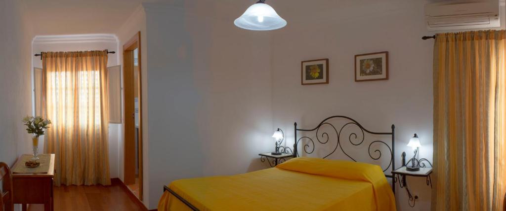 Vera Cruz de MarmelarQuinta da Fonte do Lugar的一间卧室配有一张黄色毯子床