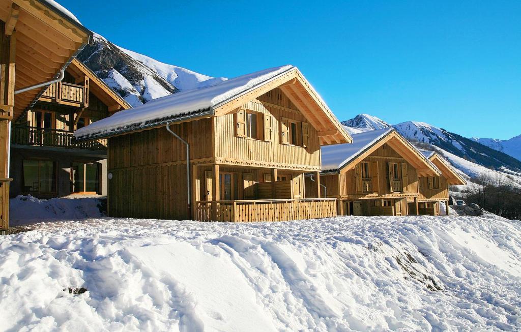 圣索林达尔沃Résidence Odalys Les Chalets de l'Arvan II的雪中的一个圆木度假屋,背景是群山