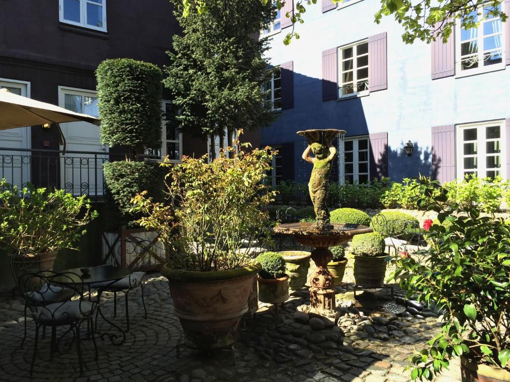 奥胡斯普罗旺斯别墅酒店的一座花园,在一座建筑的中间有一个雕像
