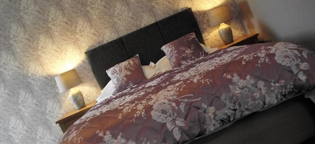 基德灵顿斯塔迪斯城堡酒店的一间卧室配有一张带红色被子的床和两盏灯。