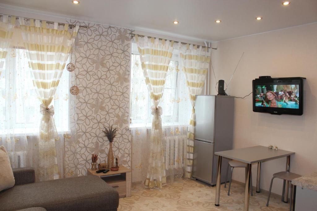 季赫温Apartments 4 Mikrorayon的客厅配有沙发和墙上的电视