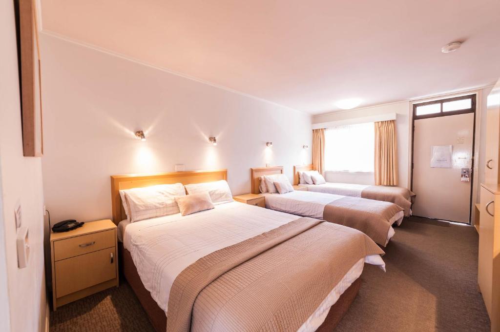 吉朗东部沙滩中心酒店的酒店客房设有三张床和窗户。