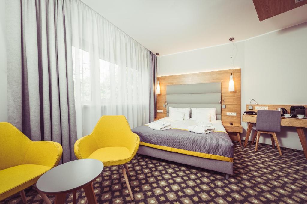 波兹南维瓦尔第酒店的酒店客房配有一张床、椅子和一张书桌