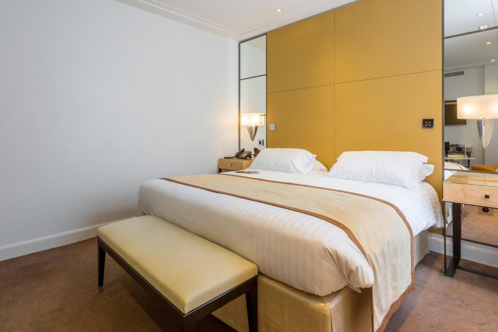 巴黎卡斯蒂尼奥那酒店的一间卧室设有一张黄色墙壁的大床