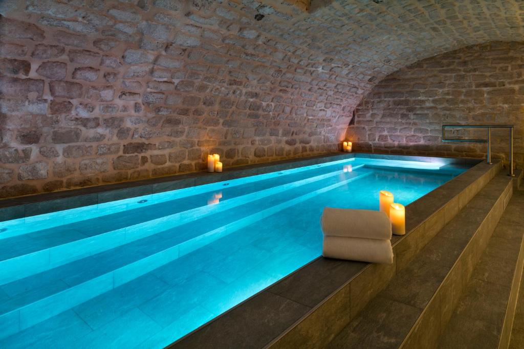 巴黎卢瓦斯广场酒店的一座游泳池,位于带游泳池的砖墙客房