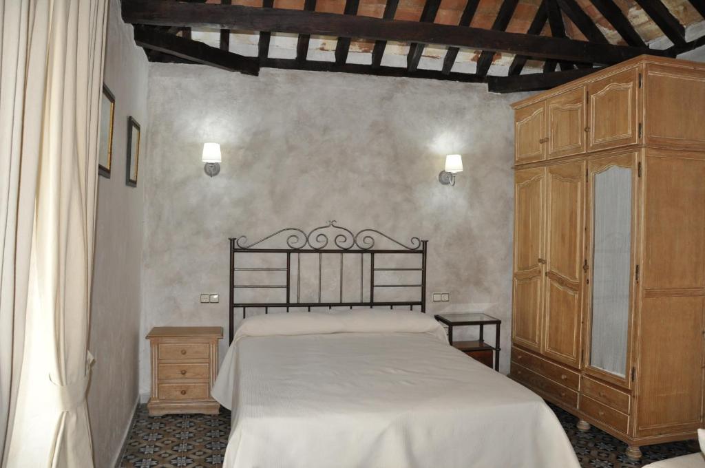EsteponaCasa de las Remigias的一间卧室配有一张大床和一个木制橱柜