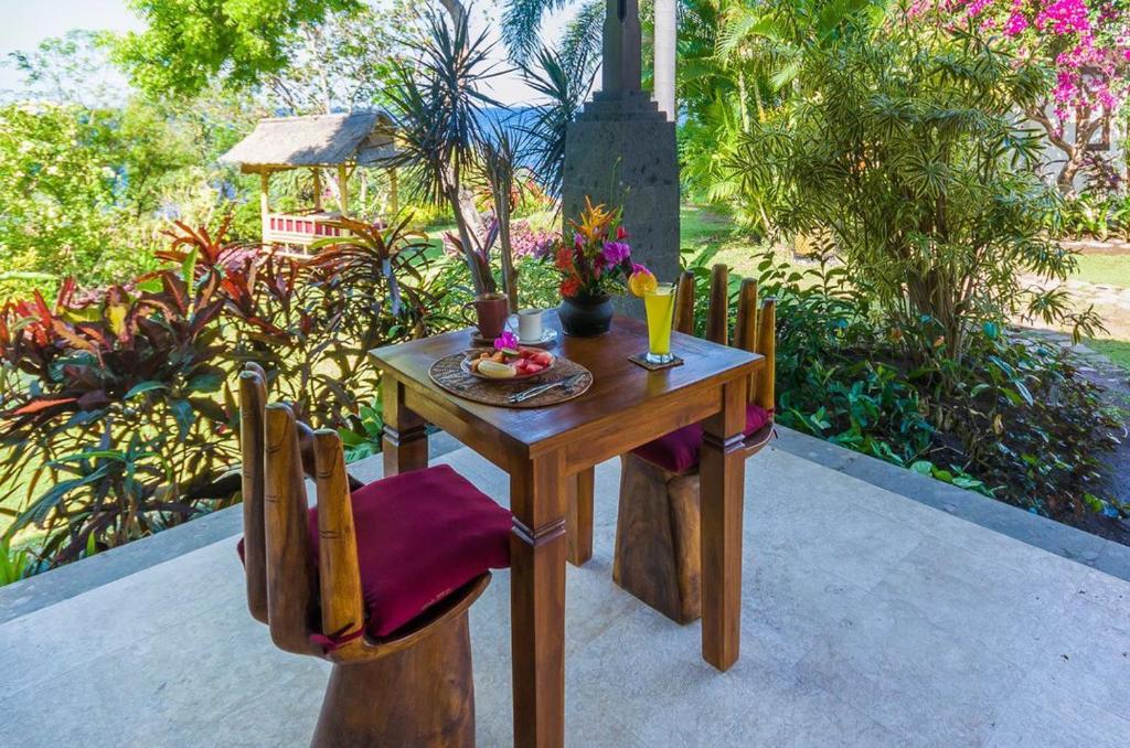图兰奔托雅巴利潜水放松假日公园的一张木桌和椅子,上面放着一碗水果
