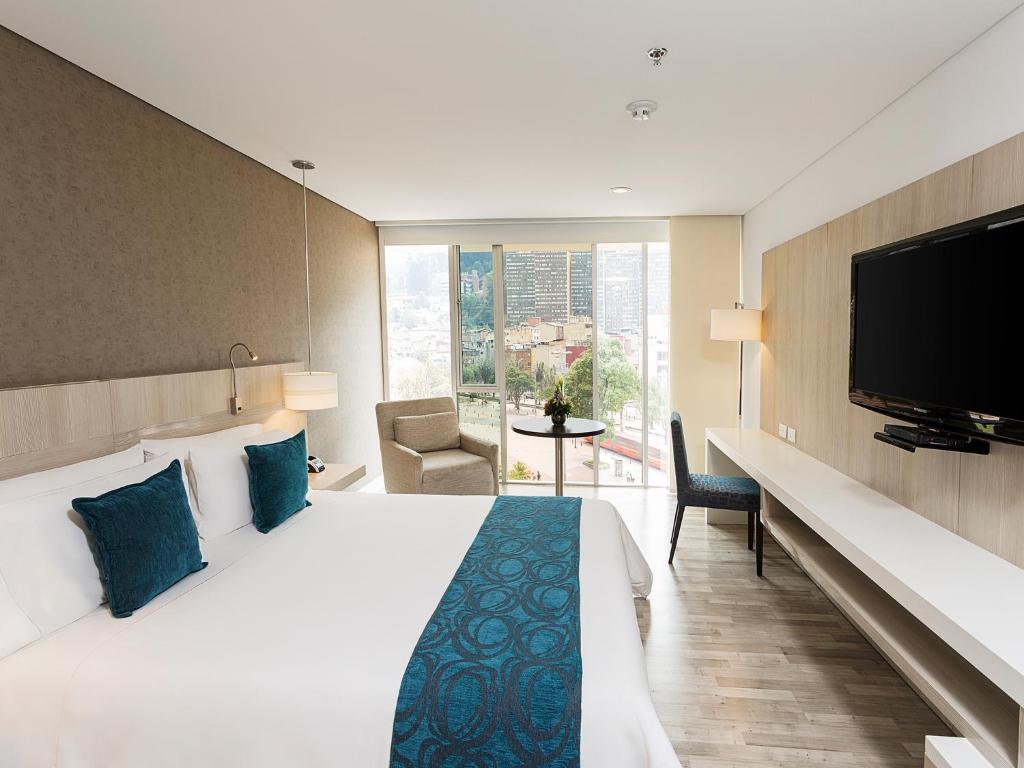 波哥大BH比森特纳里奥酒店的配有一张床和一台平面电视的酒店客房