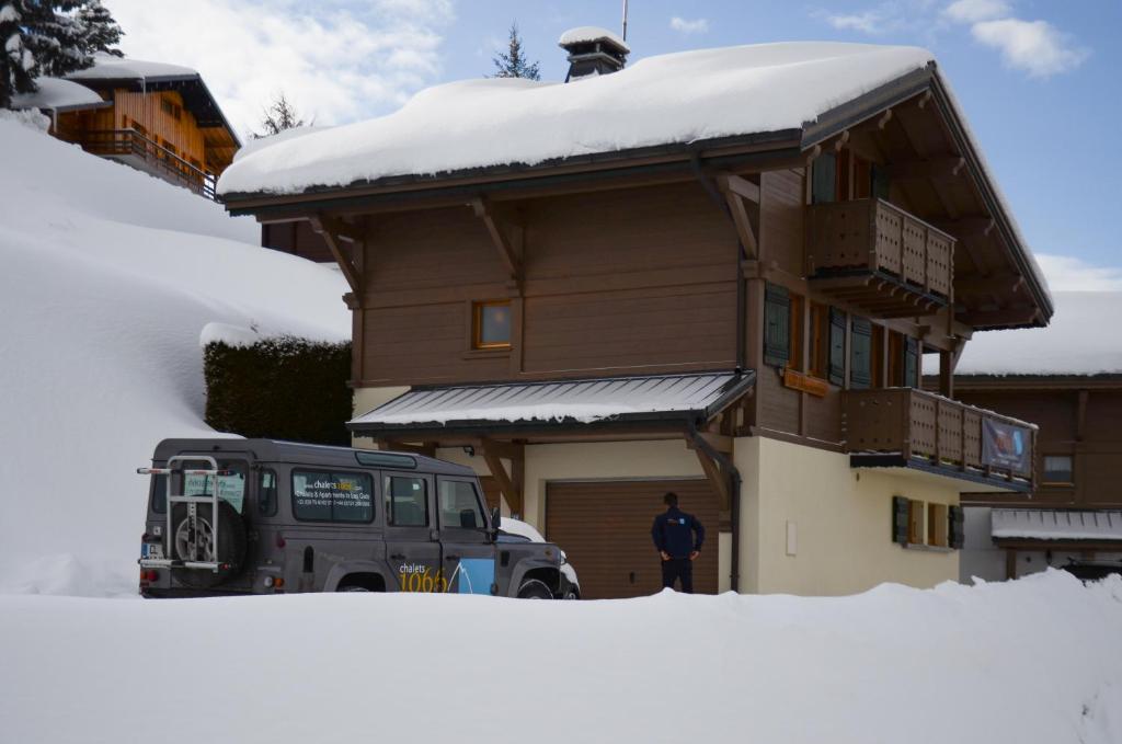 莱热Chalet Le Lapye的站在雪中房子前面的人