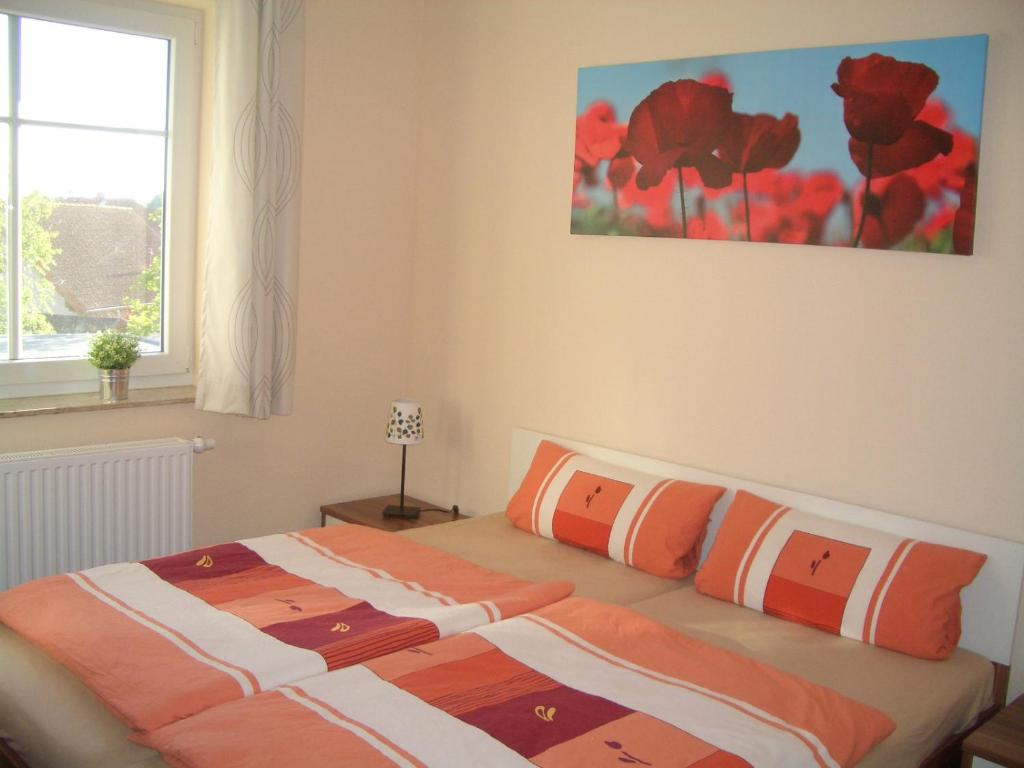 奥斯特巴德里克Ferienwohnung Rerik的一间卧室配有带橙色和白色枕头的床