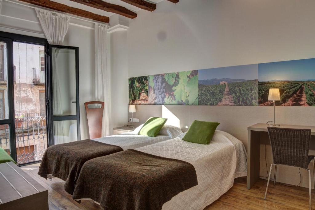 埃布罗河畔莫拉Hostal Agrobotiga 7 de Ribera的一间卧室配有一张带绿色枕头的床和一张书桌