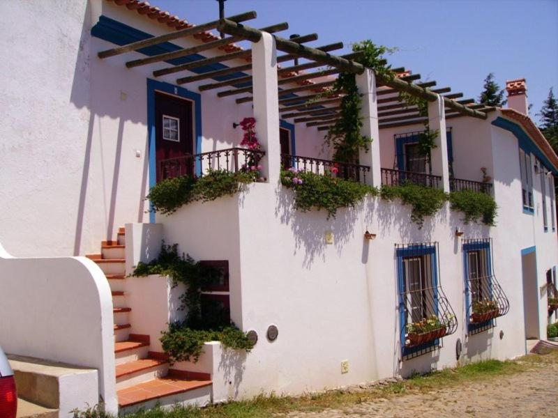 马尔旺Turimenha的一座白色的建筑,上面有楼梯和植物