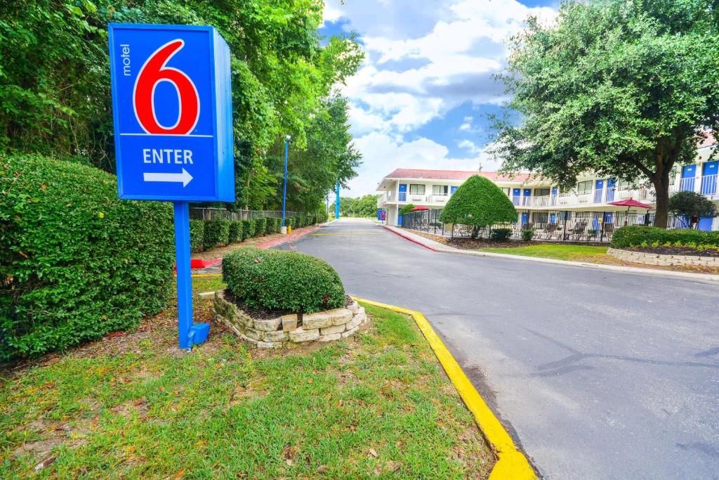 亨茨维尔Motel 6-Huntsville, TX的道路一侧的入门标志