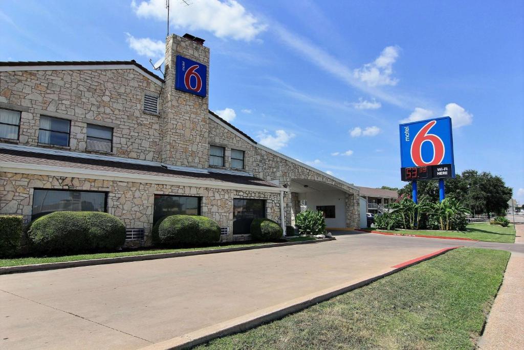 奥斯汀Motel 6 Austin, TX - Central Downtown UT的前面有标志的建筑