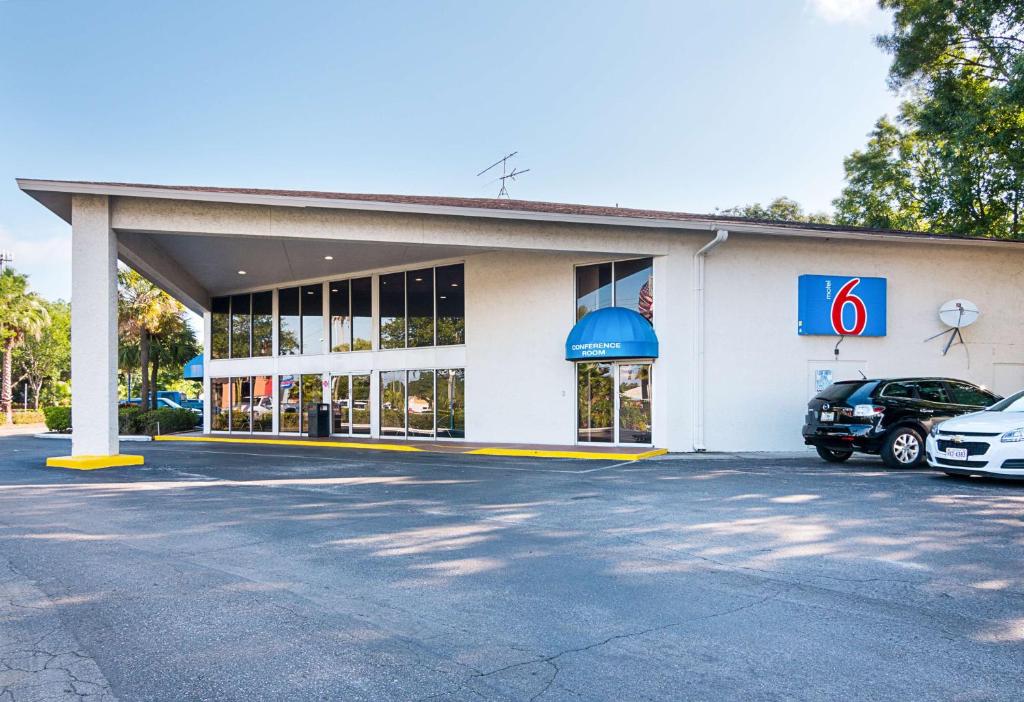 坦帕Motel 6-Tampa, FL - Fairgrounds的加油站,停在停车场的汽车