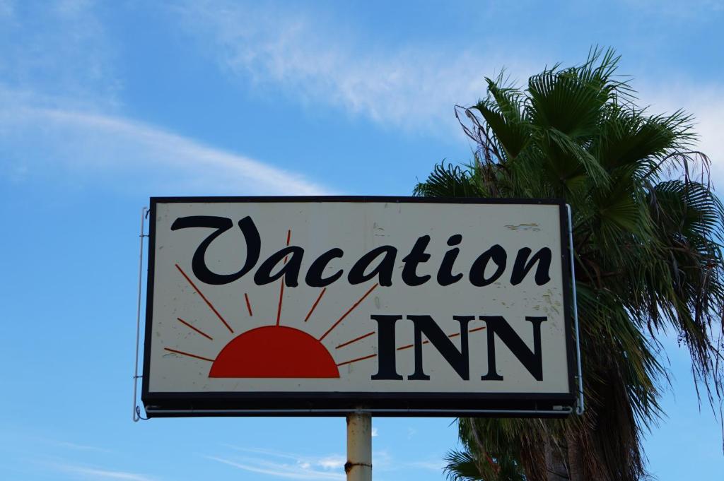 劳德代尔堡Vacation Inn Motel - Fort Lauderdale Airport的棕榈树前的度假旅馆标志