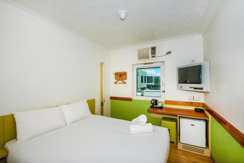 布里斯班布里斯班机场宜必思快捷酒店的卧室配有白色的床和电视。