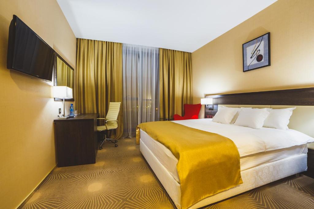 库尔斯克Aquamarine hotel&spa的酒店客房设有一张大床和一张书桌。