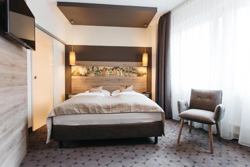 科隆锡安酒店的一间卧室配有一张大床和一把椅子