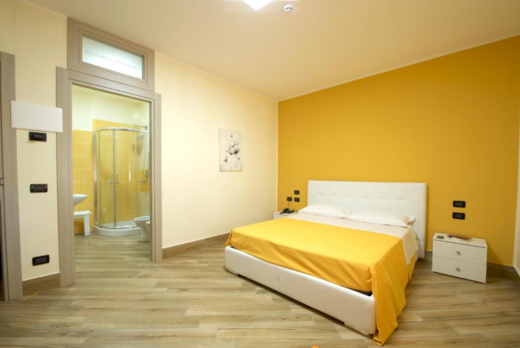 泰拉奇纳Relais Piazza Garibaldi的黄色的卧室设有床和浴室