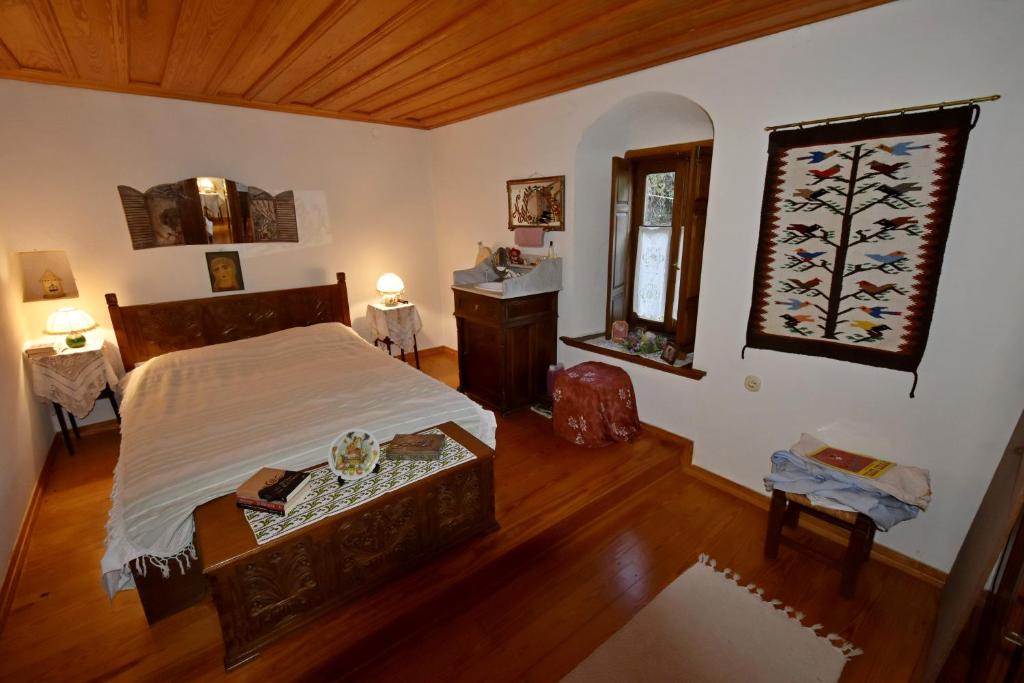 马克里尼撒Archondiko Zafeiridi的一间卧室配有一张床、一张桌子和一个窗户。