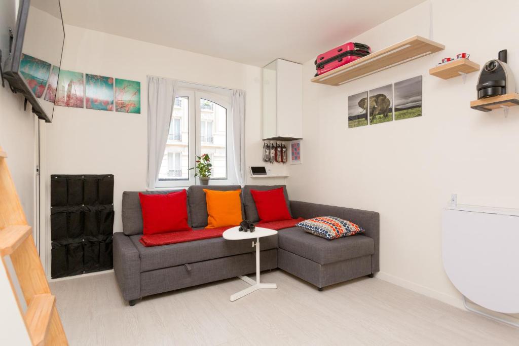 巴黎在圣日耳曼德培拉丁区巴黎圣母院奢华套房公寓的客厅配有红色和橙色枕头的沙发