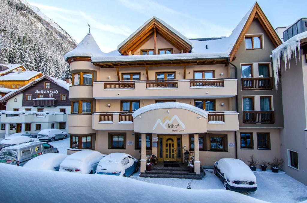 伊施格尔Hotel Idhof的雪地里的一个酒店,汽车停在停车场