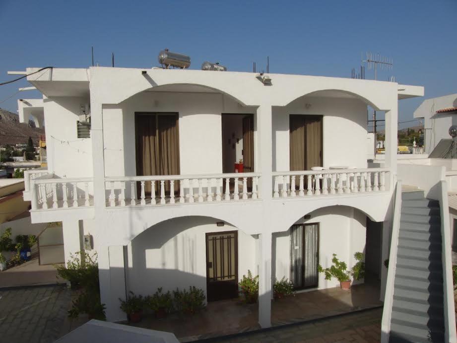 阿彻奇洛斯安诺拉旅馆的一座白色的建筑,上面设有一个阳台