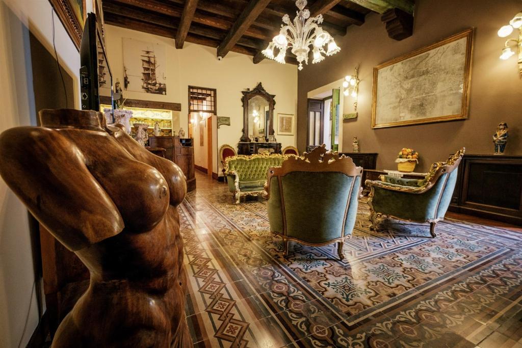 锡拉库扎亨利之家酒店的一间客厅,客厅中间设有雕像
