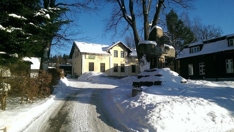 哈拉霍夫Hvězda Apartments的房屋前有积雪的街道