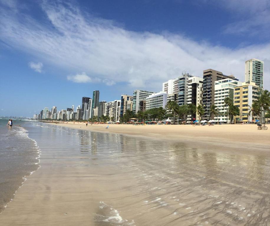 累西腓Extraordinary Seafront Apartment的一片拥有建筑背景和海洋的沙滩