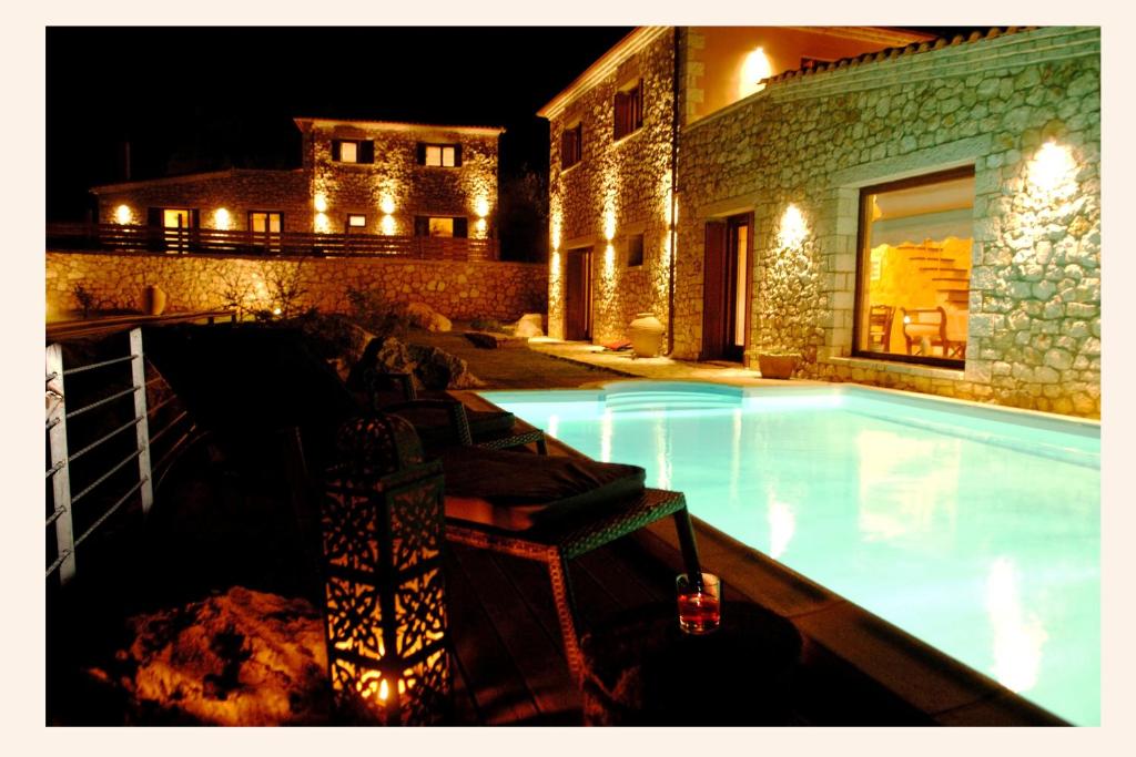 梅加尼西岛Villa Danae的一座游泳池,在晚上在建筑物前