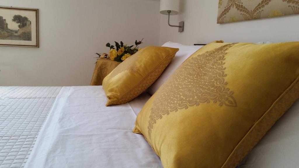卡塞塔L'Insolita Reggia的一张带黄色毯子和枕头的床