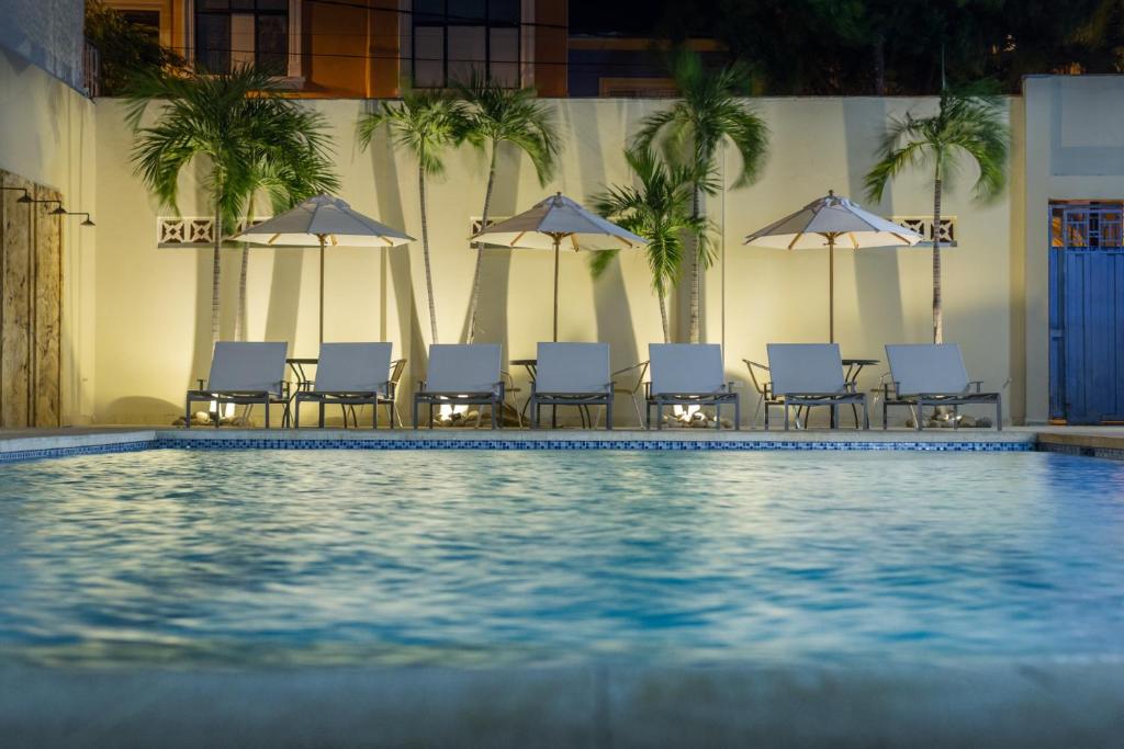 吉拉尔多特Hotel San German的一个带椅子和遮阳伞的游泳池