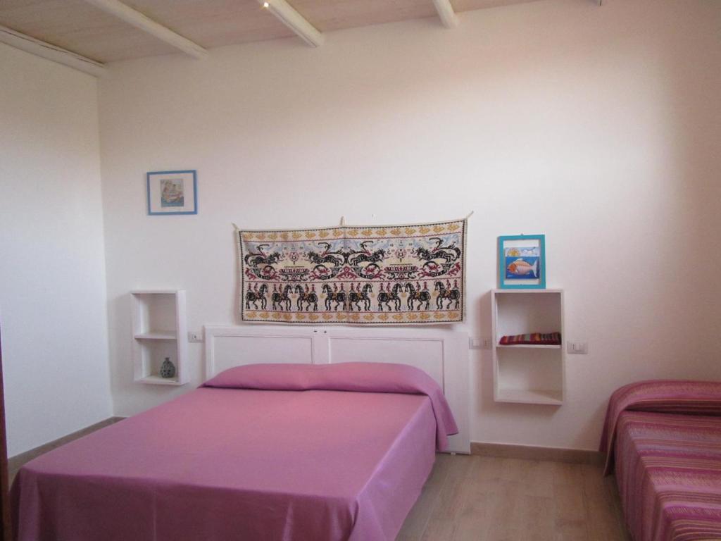 特乌拉达B&B Su Tostainu的一间卧室配有一张带紫色毯子的床