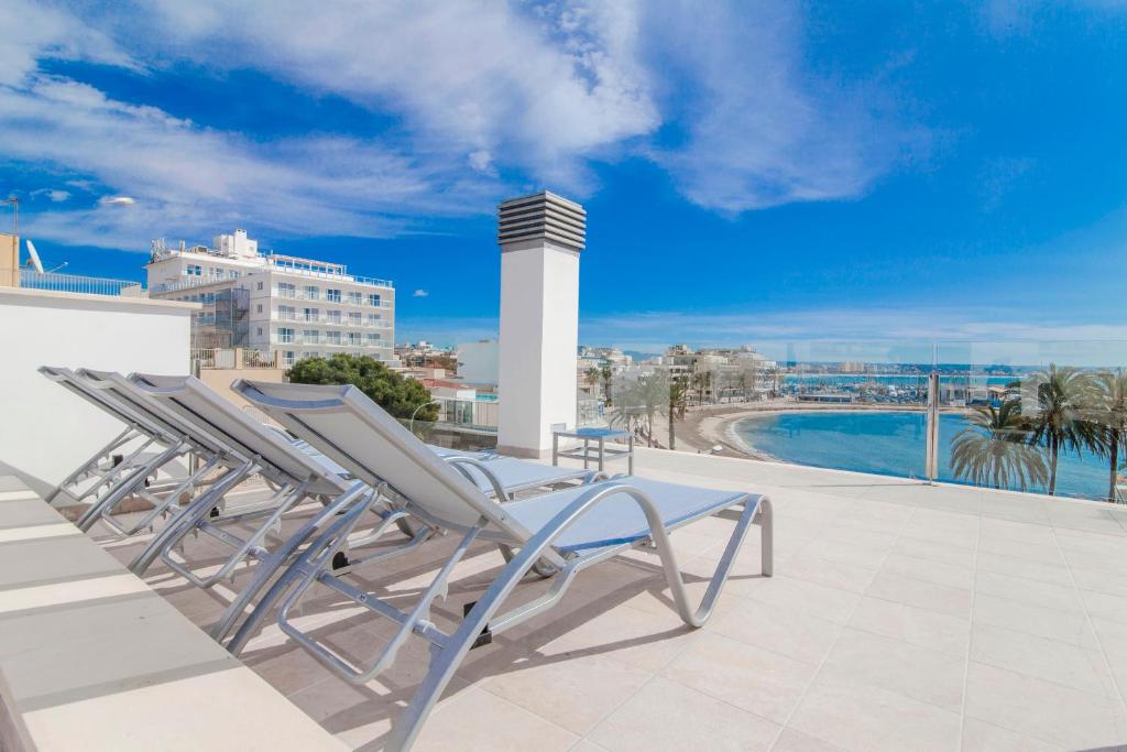 坎帕斯蒂利亚Apartments Beach 4U - Can Pastilla的建筑物屋顶上的一把躺椅