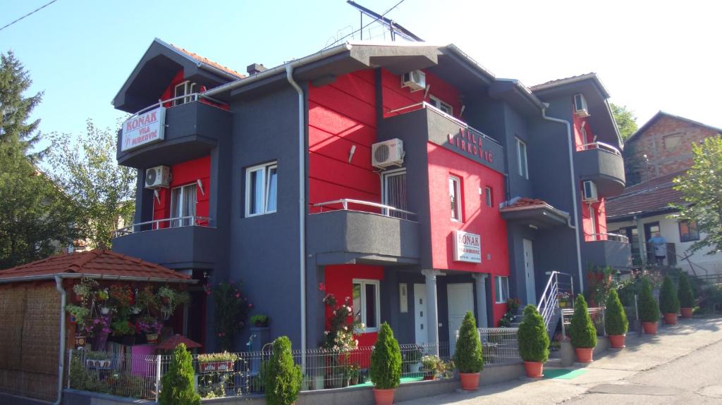 索科矿泉村KONAK ViLA MIRKOVIĆ的一座红蓝色的建筑,前面有植物