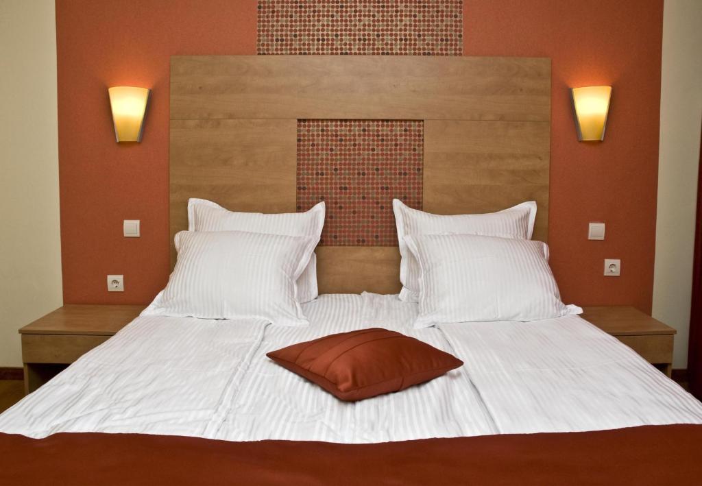 索非亚佐娜酒店4号的一张白色的大床,上面有棕色枕头
