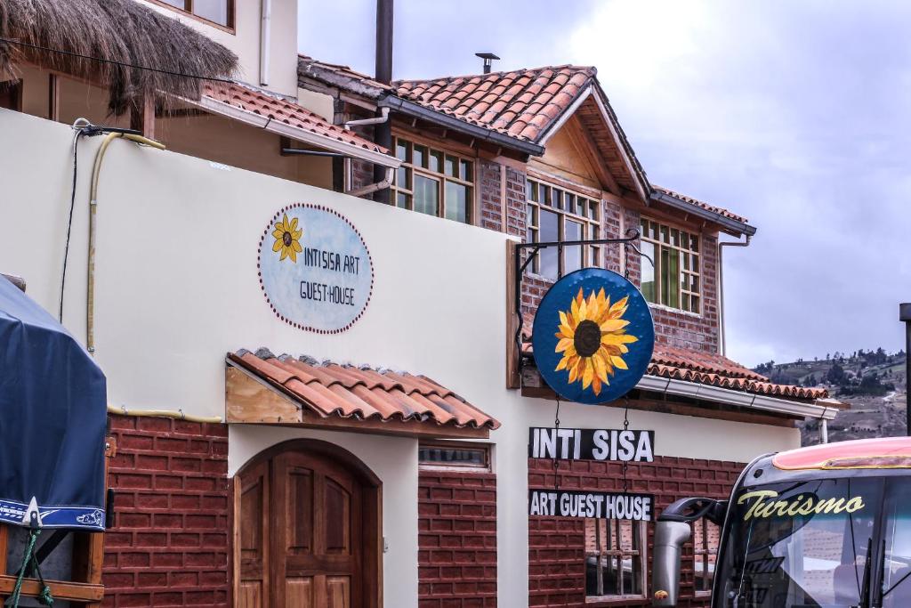 GuamoteInti Sisa Art Guesthouse的一座建筑的侧面有向日葵标志