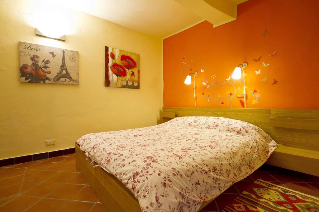 奥尔塔圣朱利奥卡梅拉多切诺特旅馆的一间卧室配有一张橙色墙壁的床