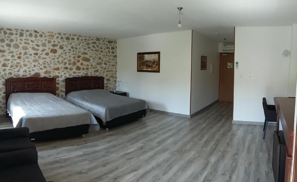 Bélesta帕莱斯卡特里酒店的酒店客房设有两张床和一张桌子。