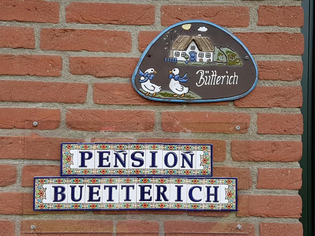 胡苏姆Pension Bütterich的砖墙墙上的标志