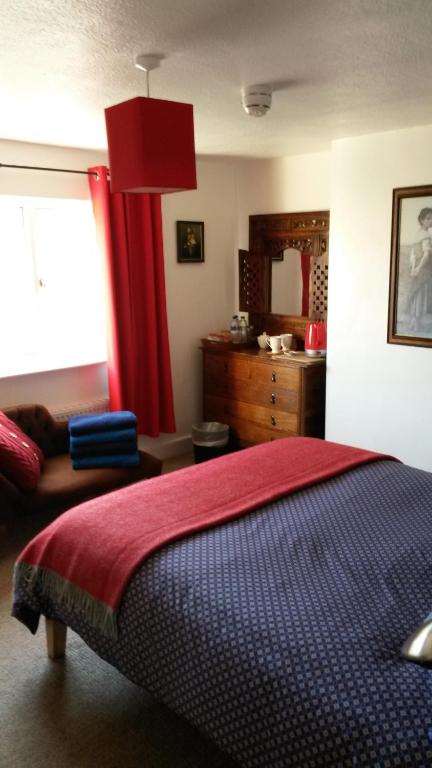 斯伯丁波德霍尔住宿加早餐旅馆的一间卧室配有床和红色窗帘