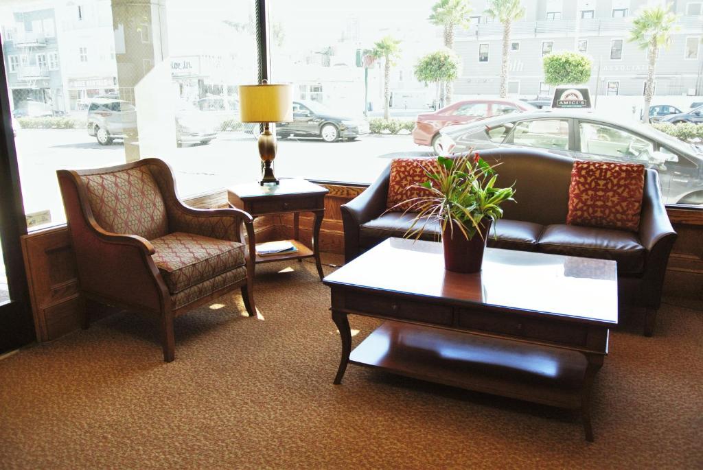 旧金山牛谷旅馆及套房酒店的客厅配有两把椅子、一张沙发和一张桌子