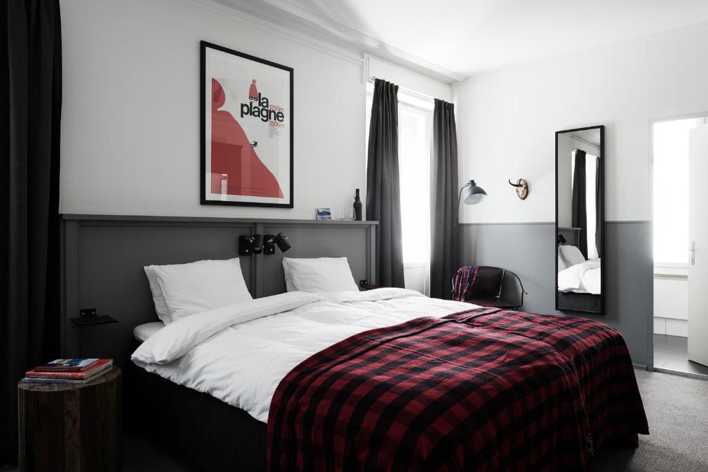 英格堡英格堡滑雪酒店的一间卧室配有一张大床和一张铺着条纹毯子